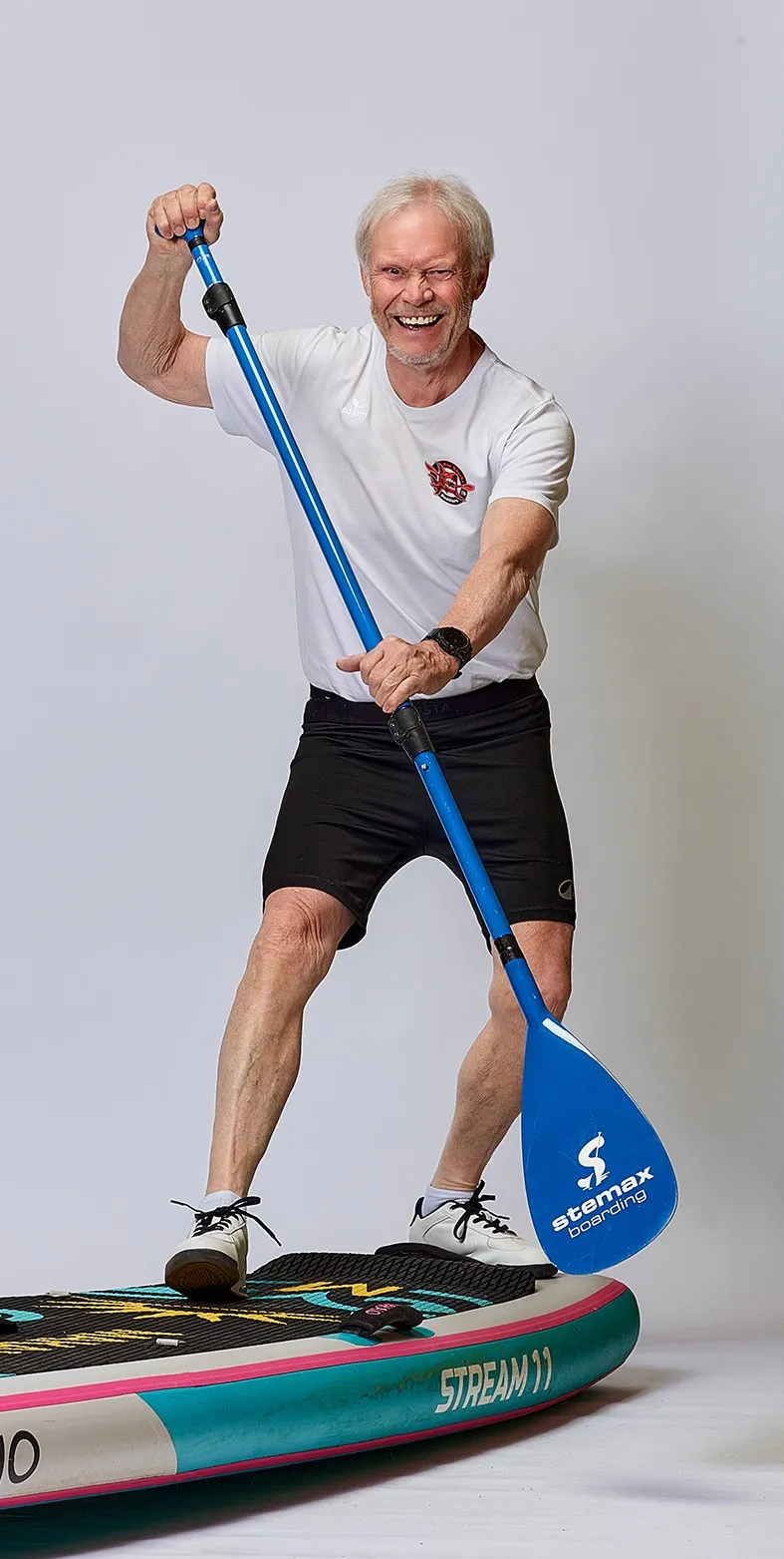 Mann in Deutschland-Shirt und Paddel auf Stand-Up-PaddleBoard 