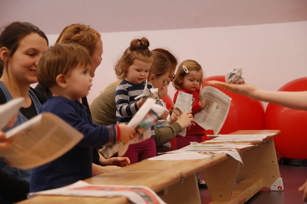 Mehrere Kinder stehen vor einer Turnhallen-Bank.