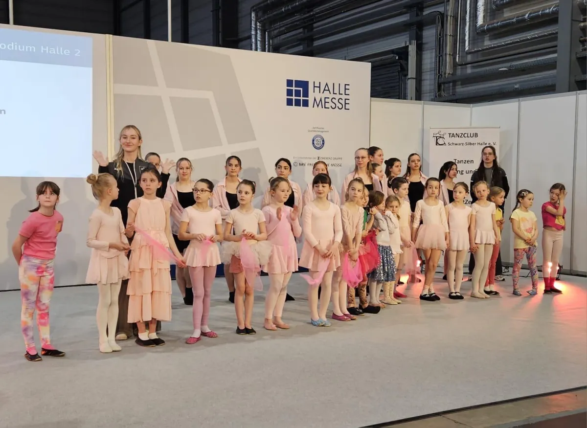 Auftritt Messe März 2025 -Tanzgruppe in Kostümen auf einer Bühne.