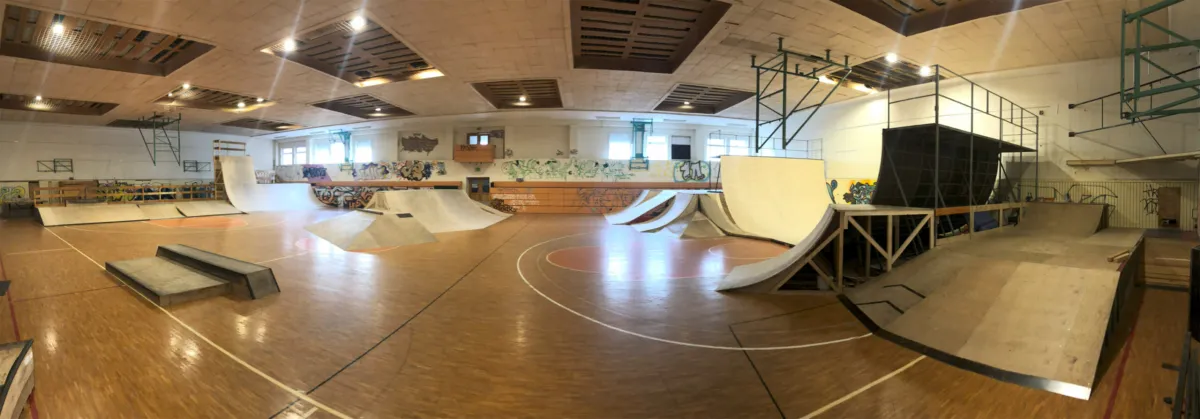 Zu sehen ist eine Skatehalle mit verschiedenen Rampen und Elementen im Weitwinkel.