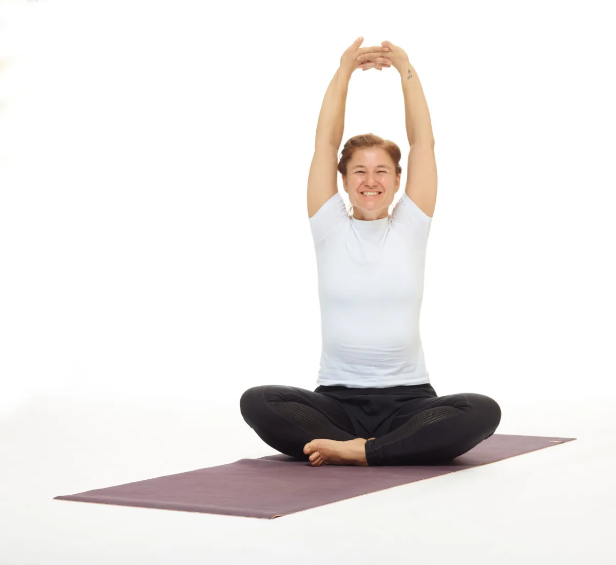 eine Person streckt ihre Arme lachend in einer Yogapose