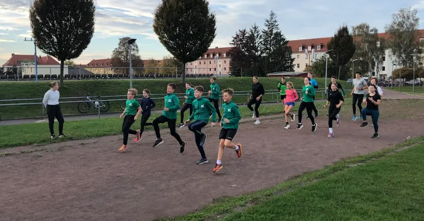 Kinder laufen auf einer Laufbahn im Lauftraining.