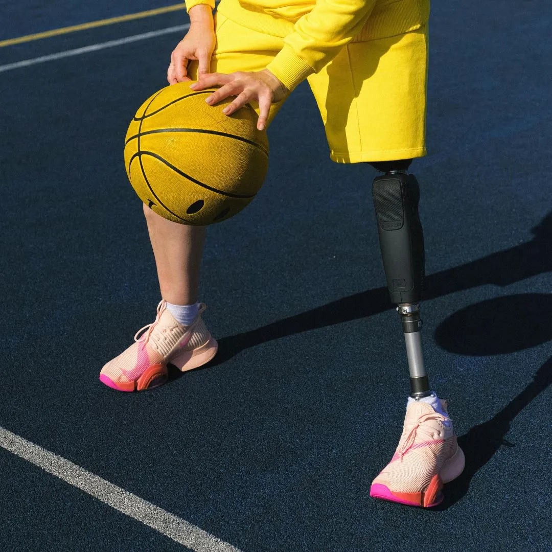 Inklusion im Sport (Foto: Canva) Zu sehen sind die Beine einer Person mit Prothese beim Dribbeln eines Basketballs.