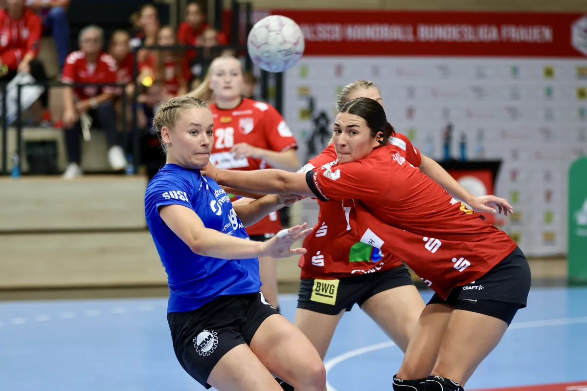 Zweikampf Handballspielrerinnen von Halle und Leipzig im Zweikampf. Sie ziehen sich gegenseitig am Trikot und schauen verbissen.