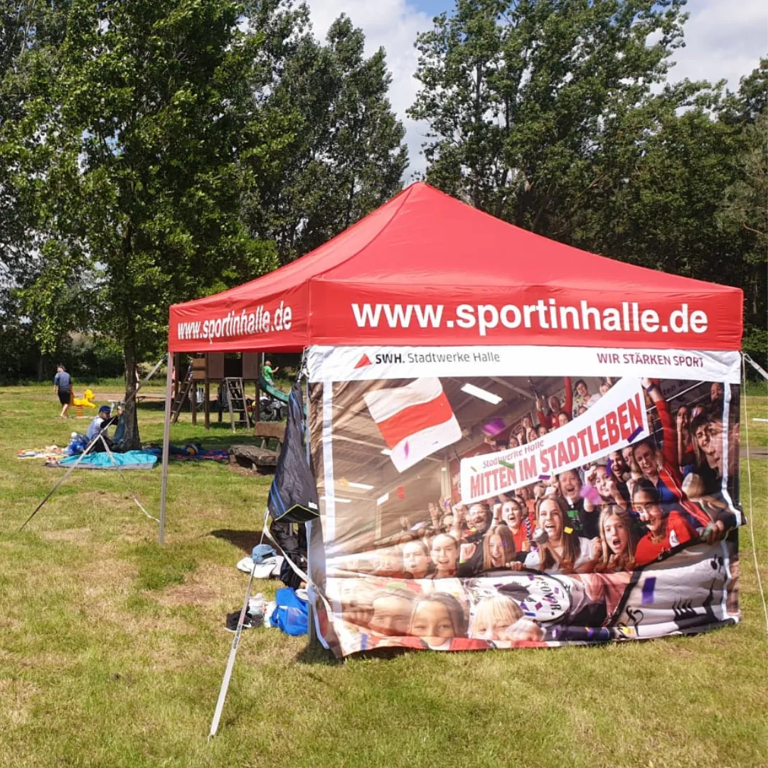 Ein kleines Veranstaltungszelt auf einer Wiese.