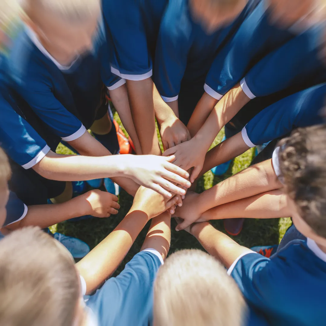 Ein Team in Trikots macht einen Kreis aus H&auml;nden