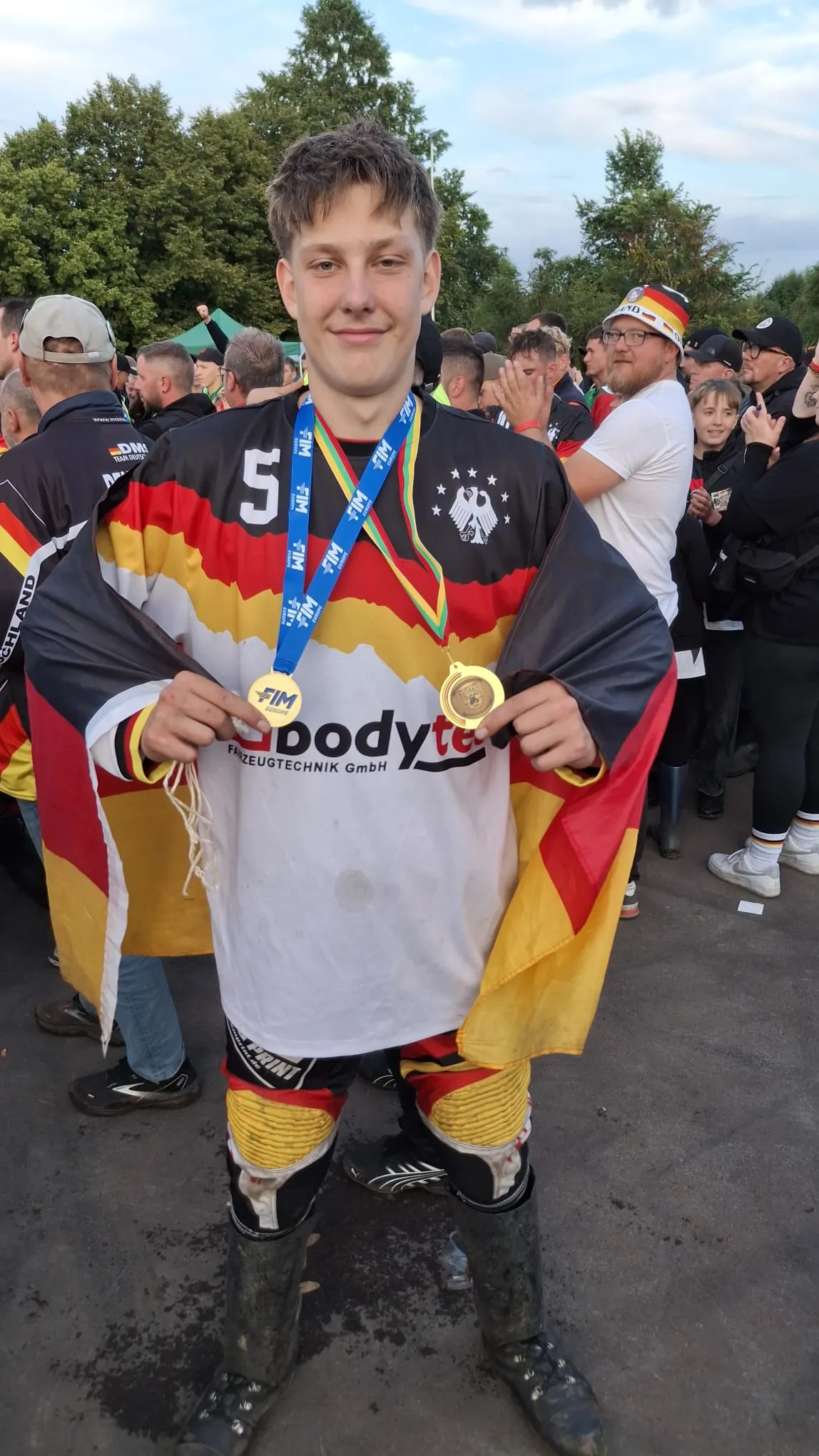 Junger Mann in Deutschland-Trikot mit zwei Medaillen um den Hals