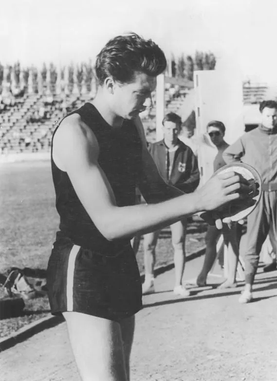 Schwarz-wei&szlig;-Foto eines Mannes in Sportkleidung mit Diskus in der Hand