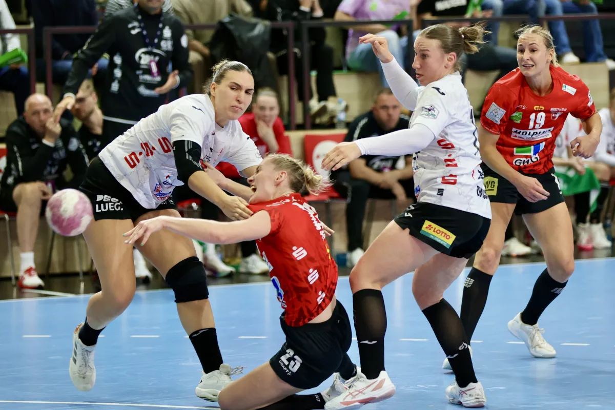 Handballspielerinnen in roten und wei&szlig;en Trikots im Zweikampf