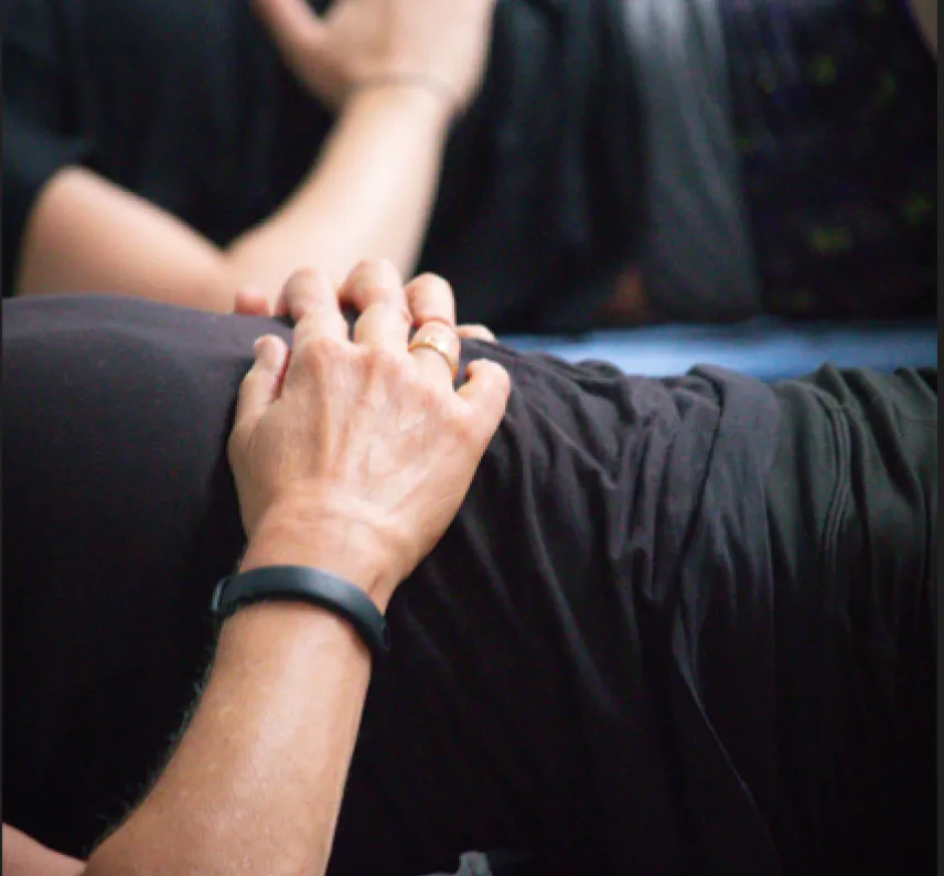 Bildausschnitt: 2 Oberkörper auf Gymnastikmatten mit den Händen auf dem Bauch. 