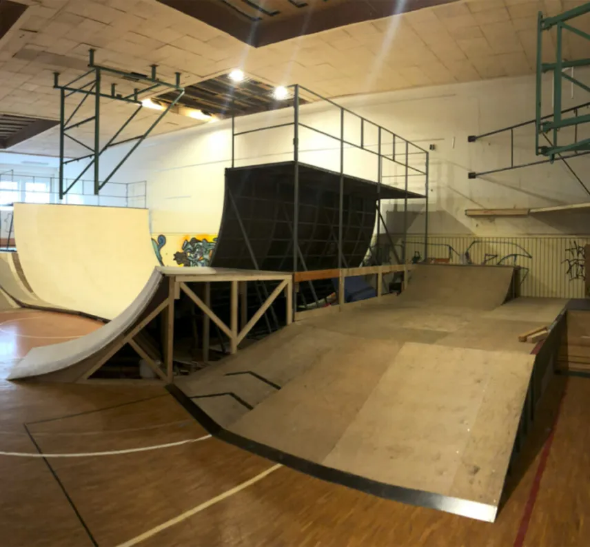 Zu sehen ist eine Skatehalle mit verschiedenen Rampen und Elementen im Weitwinkel.