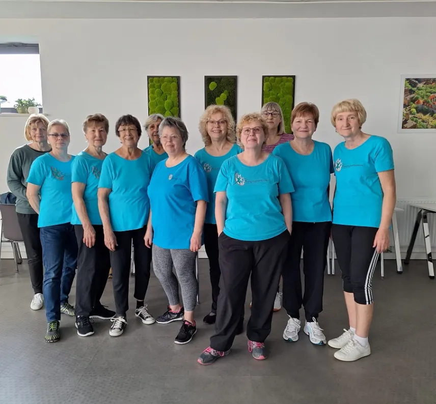 Pilates-Gruppe des FSV posiert in blauen T-Shirts. 