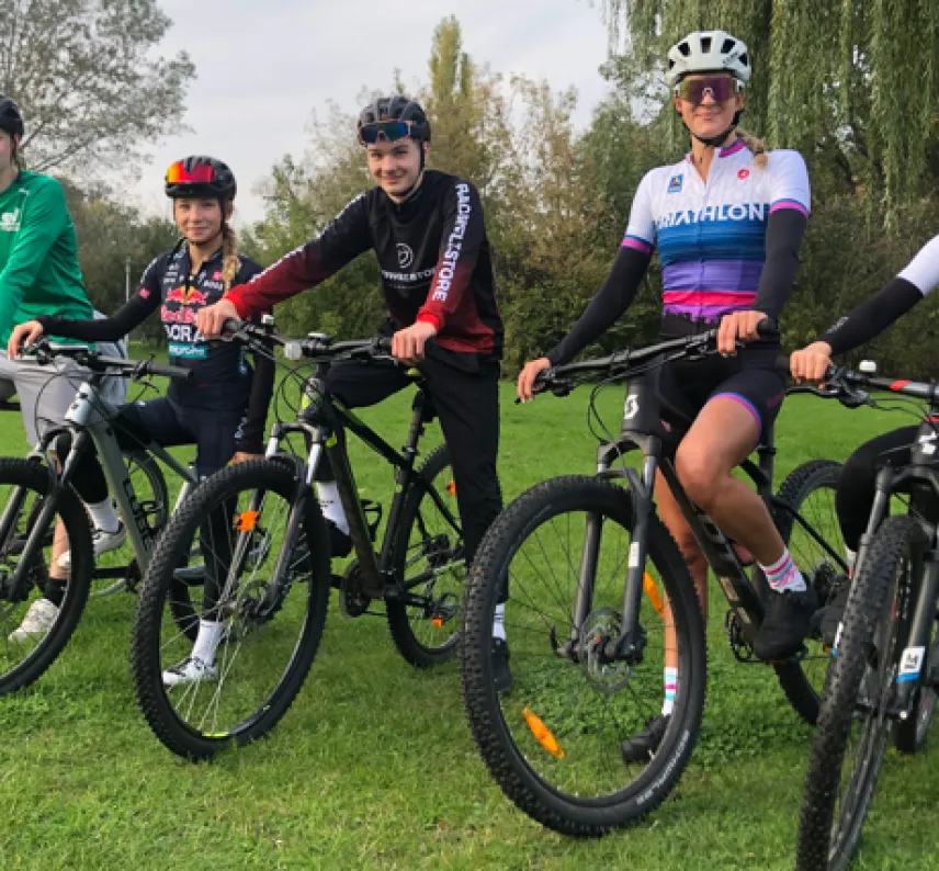 Kids Bike Fünf junge Sportlerinnen und Sportler posieren mit Rennrädern.