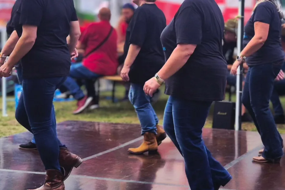 Mehrere Personen auf einer Tanzfläche machen Line Dance