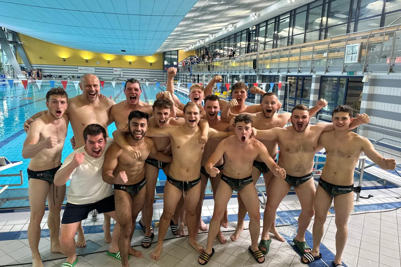 SV Halle Wasserballer SV Halle-Wasserballer in Badehosen jubelnd zum Teamfoto in Schwimmhalle aufgestellt.