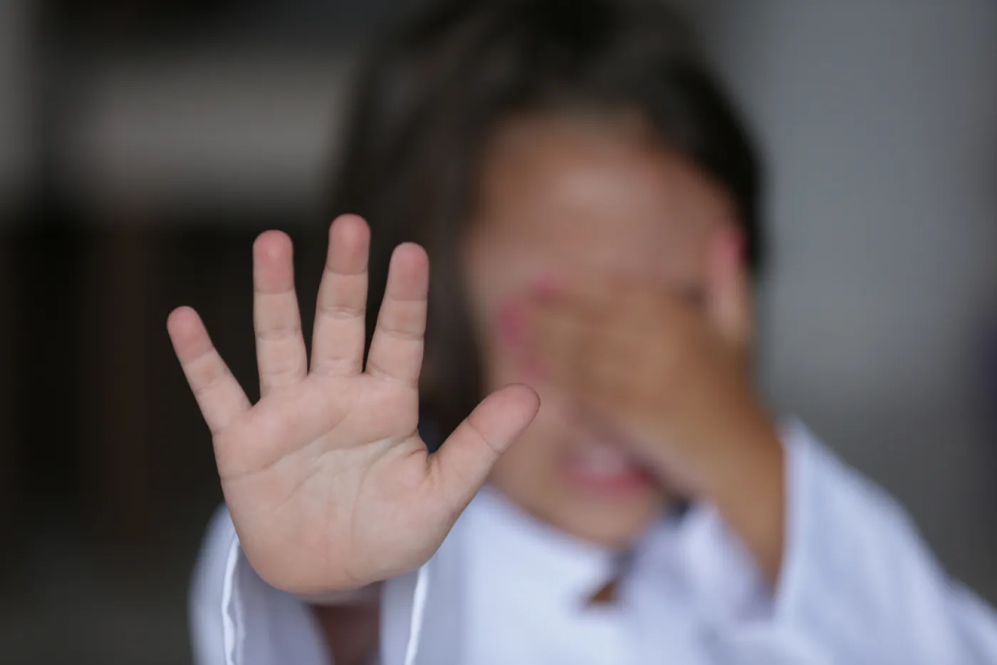 Kinderschutz im Sport Ein Kind hält den Arm mit der flachen Hand ausgestreckt vorm Körper, als wolle es etwas oder jemanden stoppen.