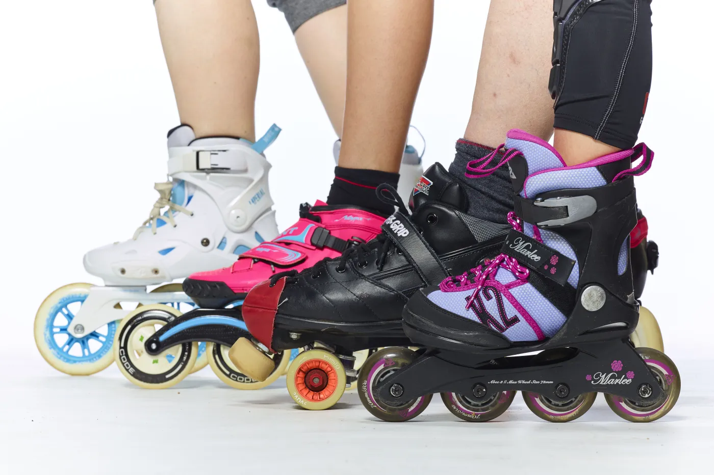 Zu sehen ist ein Bildausschnitt mit mehreren Füßen in Inlineskates, die nebeneinander aufgereiht stehen.