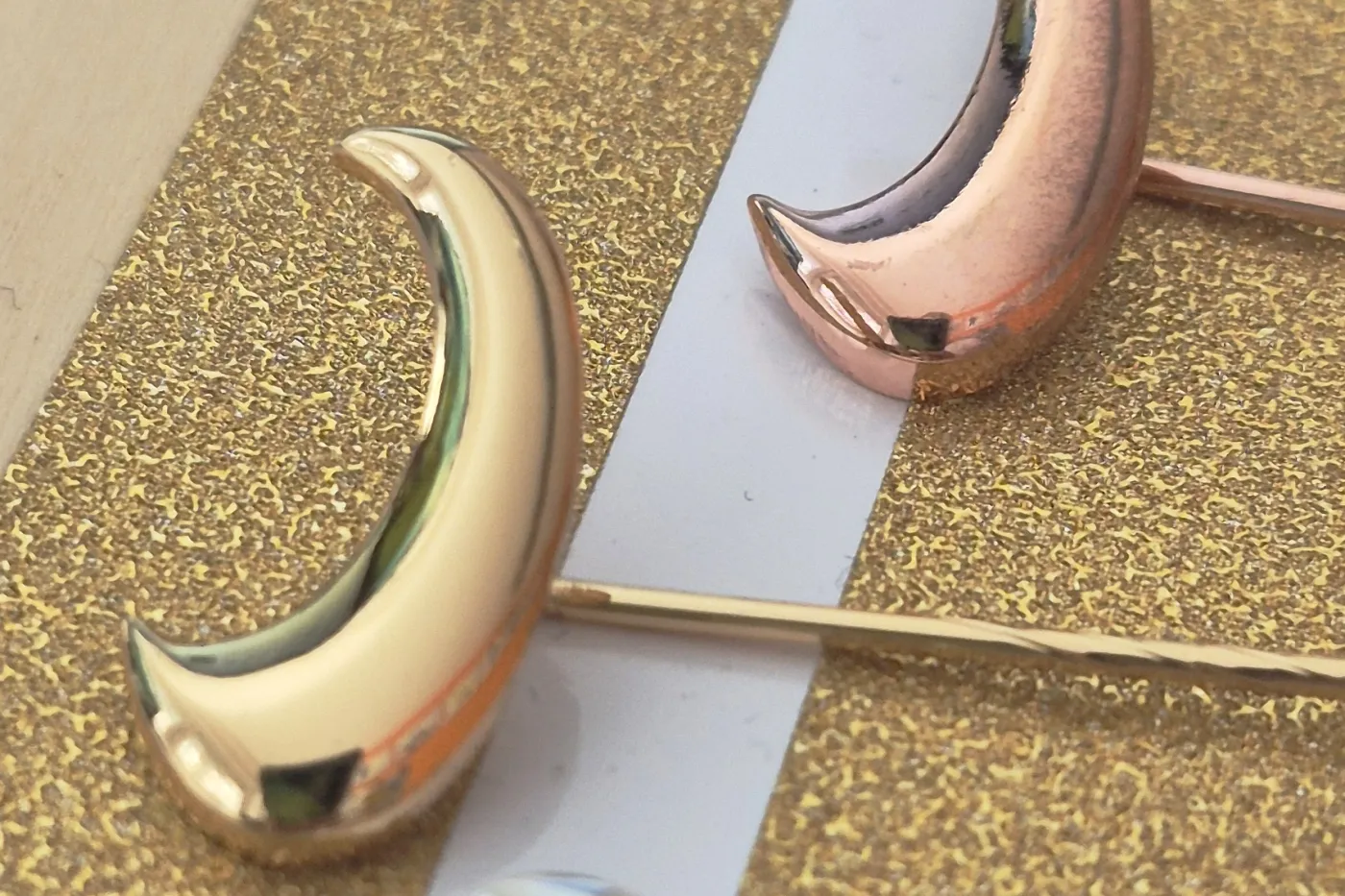 Zu sehen sind drei Ehrennadeln des SSB in Form eines stilierten Halbmondes in Silber, Gold und Bronze