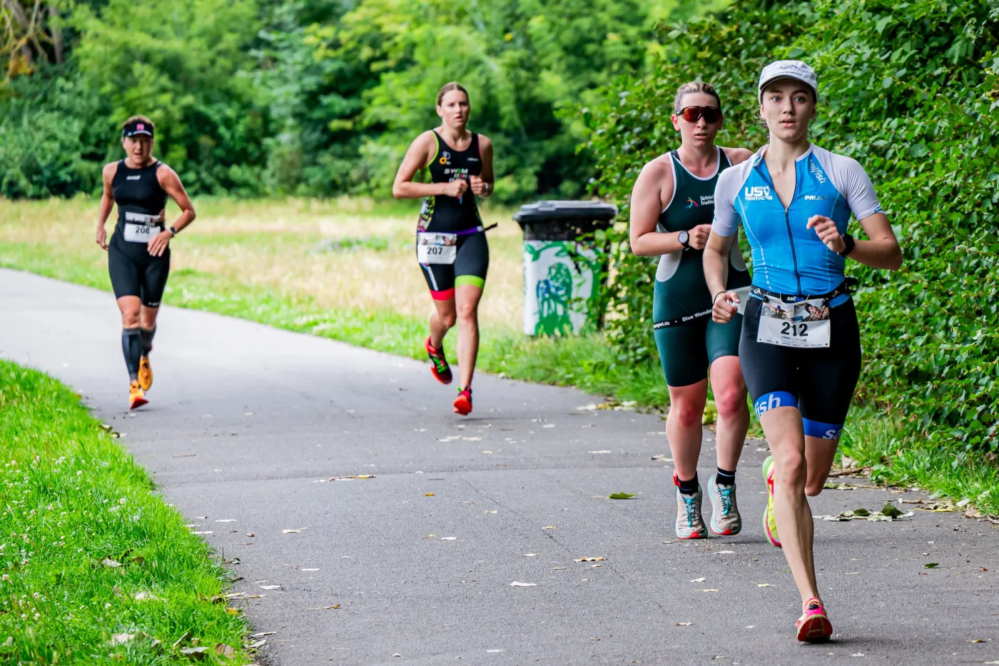 Triathlon Laufen Mehrere Läufer in Laufkleidung auf einem Weg.