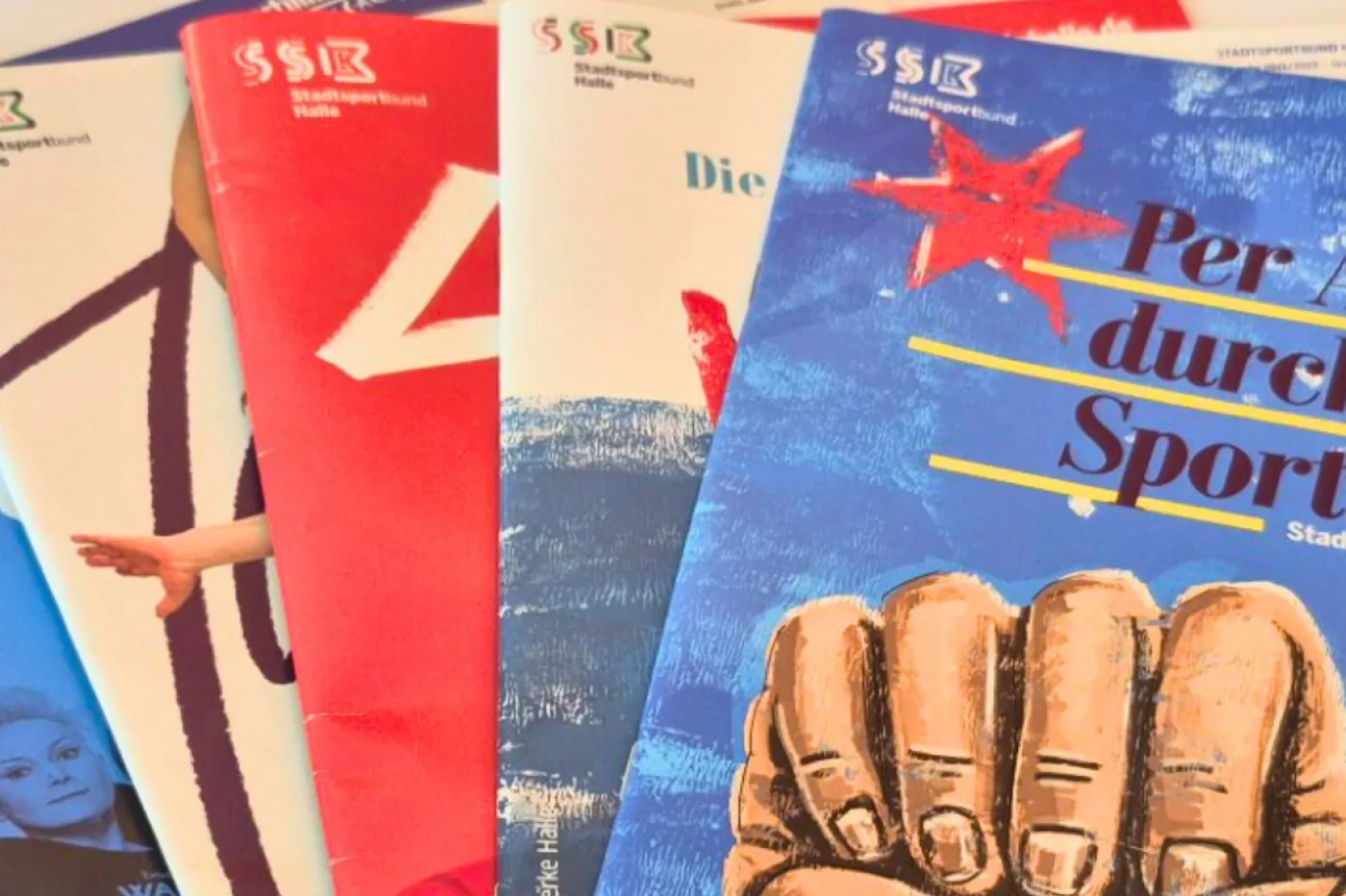 Mehrere Sportinhalle-Magazine liegen gefächert auf dem Tisch.