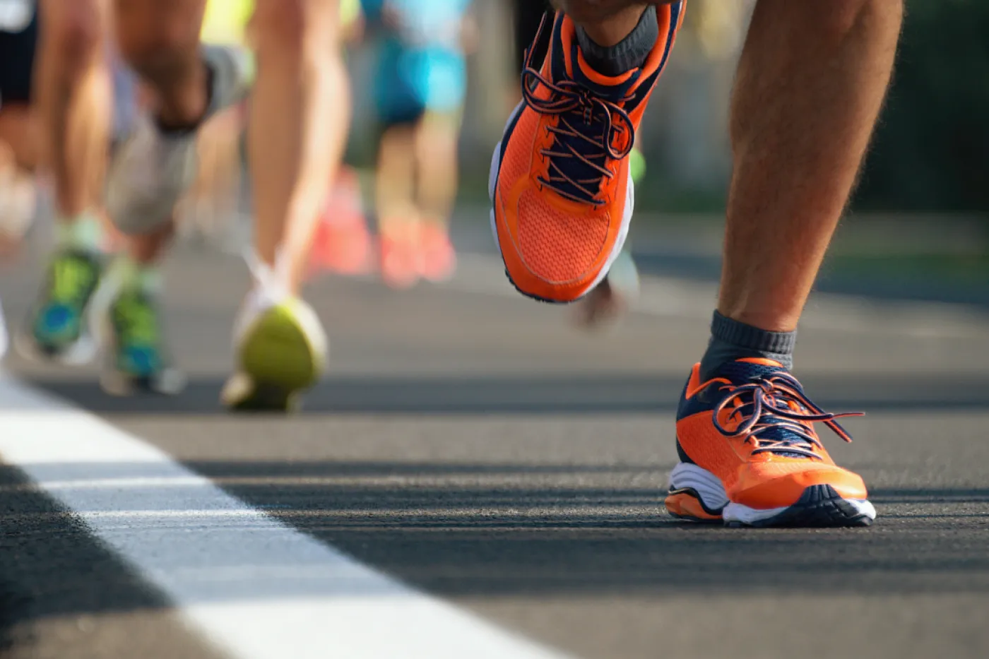 Man sieht die Beiner mehrerer Jogger mit bunten Turnschuhen.