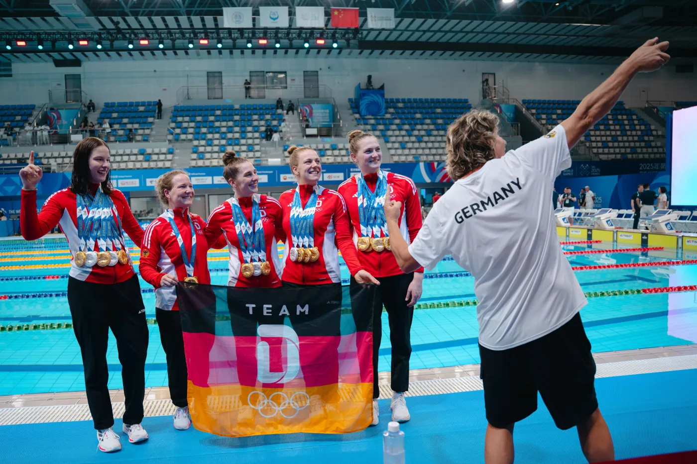 Holger Friedrich macht ein Foto mit den deutschen Rettungssportlerinnen un all ihren Medaillen.