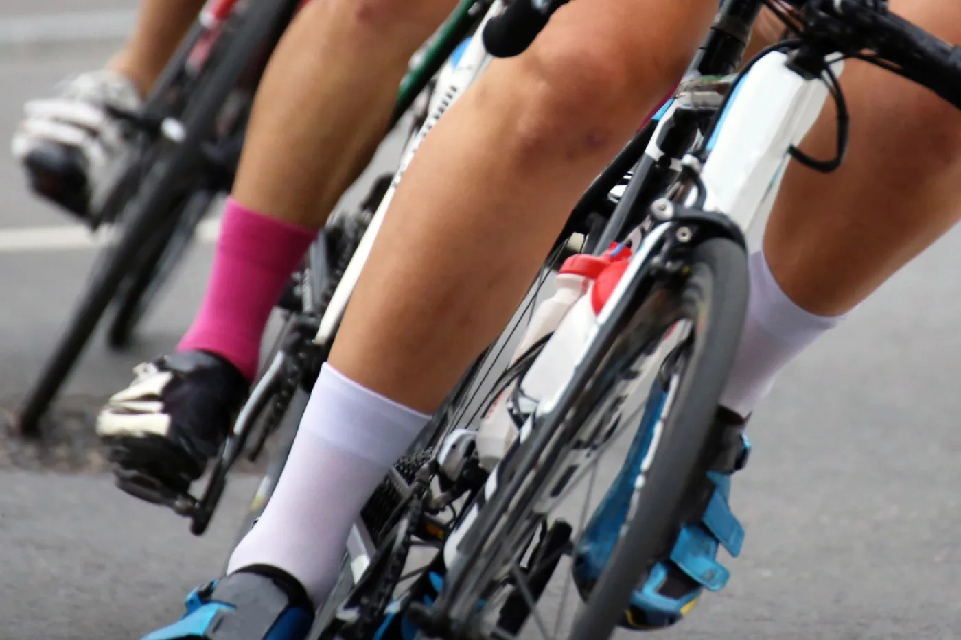 Radrennen Bildausschnitt mit mehreren Rennradfahrern auf ihren Rädern aufgereiht in einer Kurve.