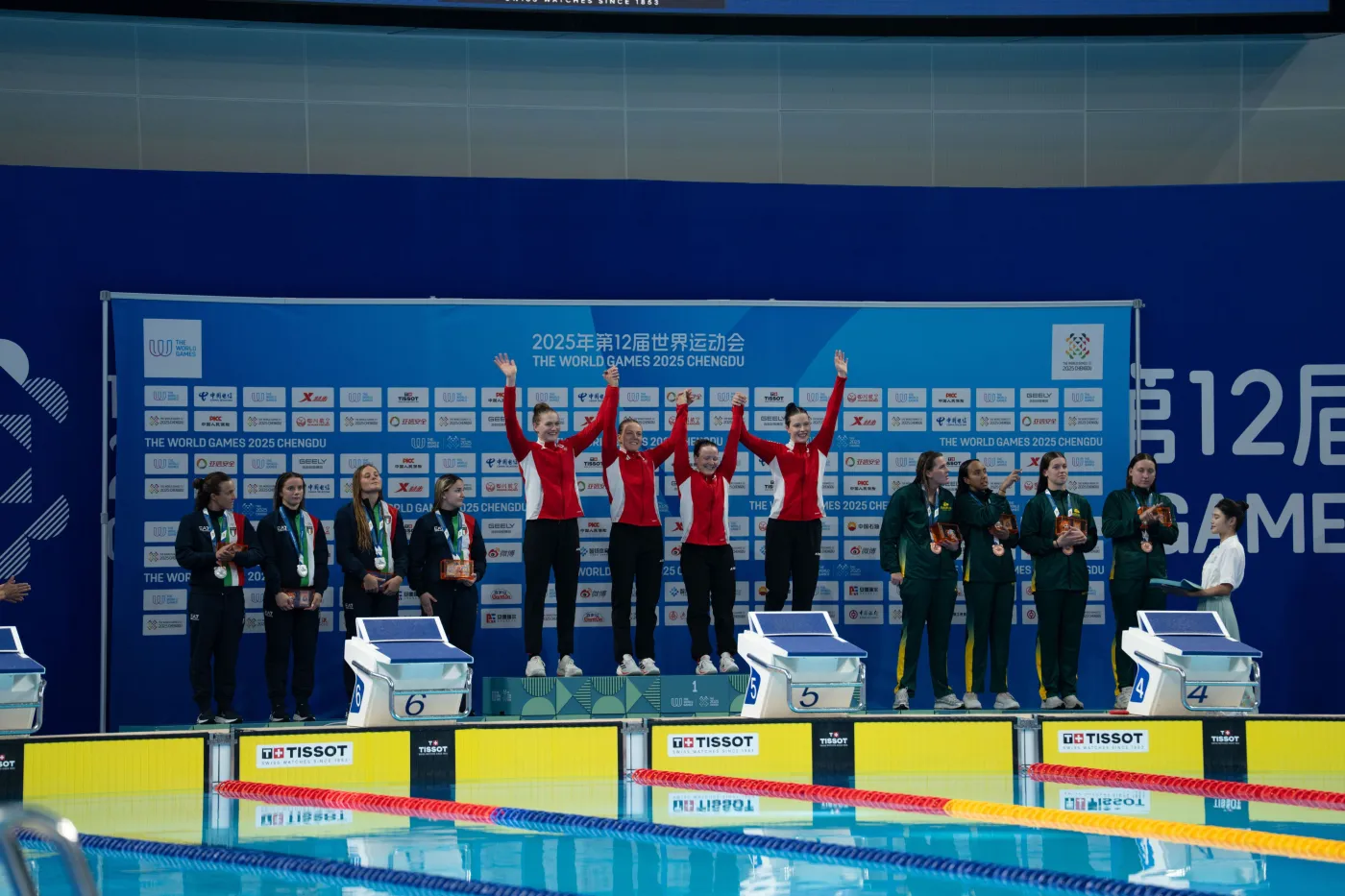 Staffelsiegerinnen Vier deutsche Rettungsschwimmerinnen auf dem Podium in Jubelpose.