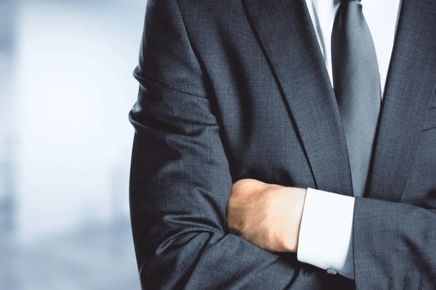 Bildausschnitt einer Person mit Anzug und Krawatte, der Kopf ist nicht zu sehen.