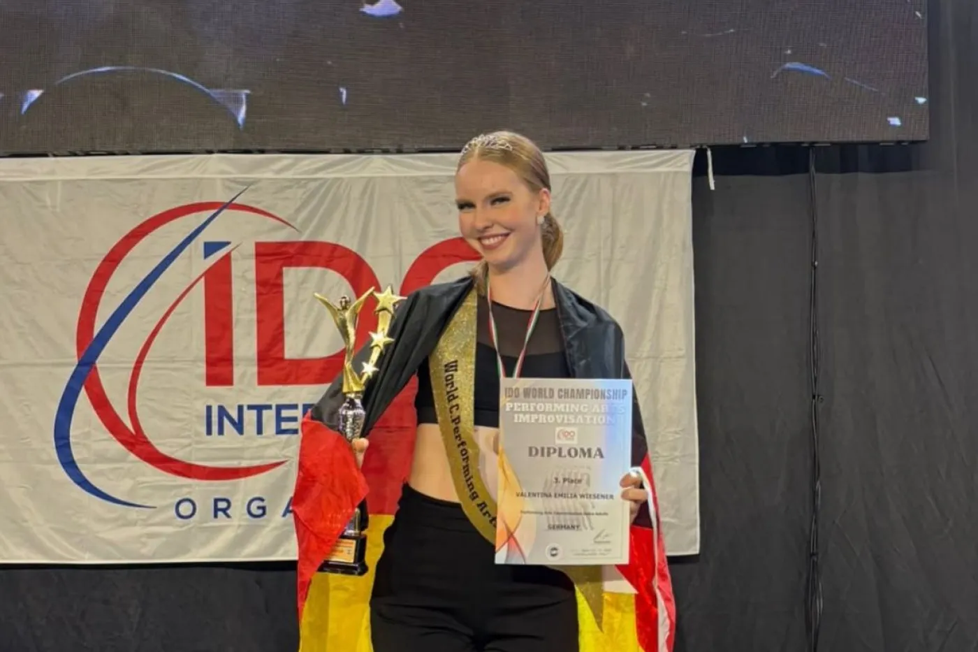Valentina Wiesener mit Pokal, Urkunde und Deutschlandfahne bei der Siegerherung.