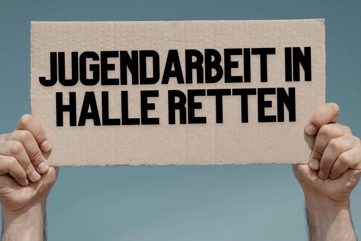 Demoschild mit Aufschrift "Jugendarbeit in Halle retten"