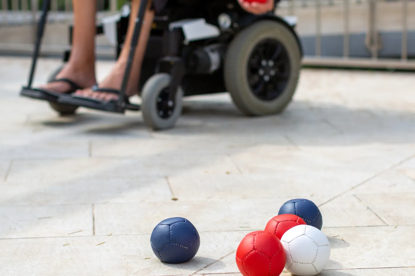Person im Rollstuhl und Bocciakugeln