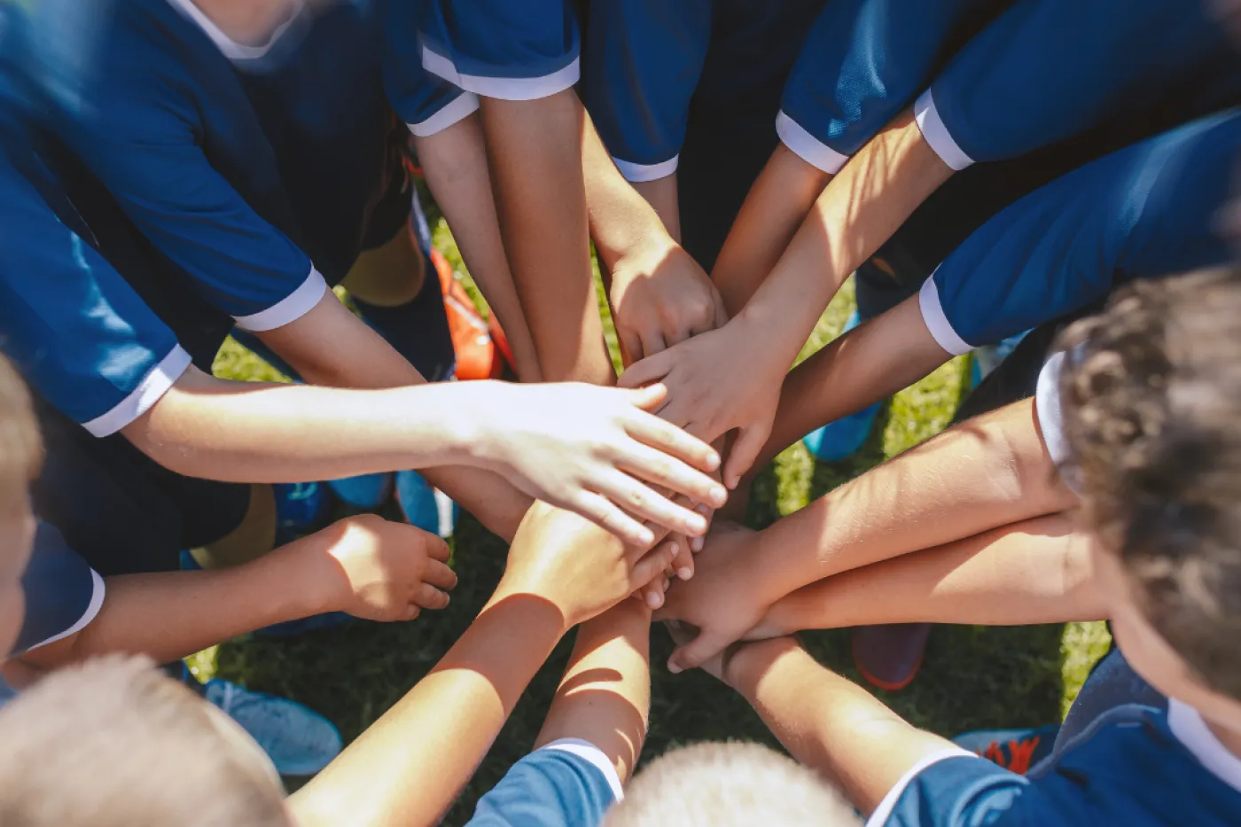 Ein Team in Trikots macht einen Kreis aus H&auml;nden