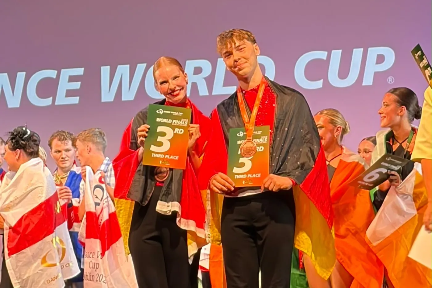 Zwei T&auml;nzer mit Medaillen, Urkunden und Deutschlandfahne auf einem Podium