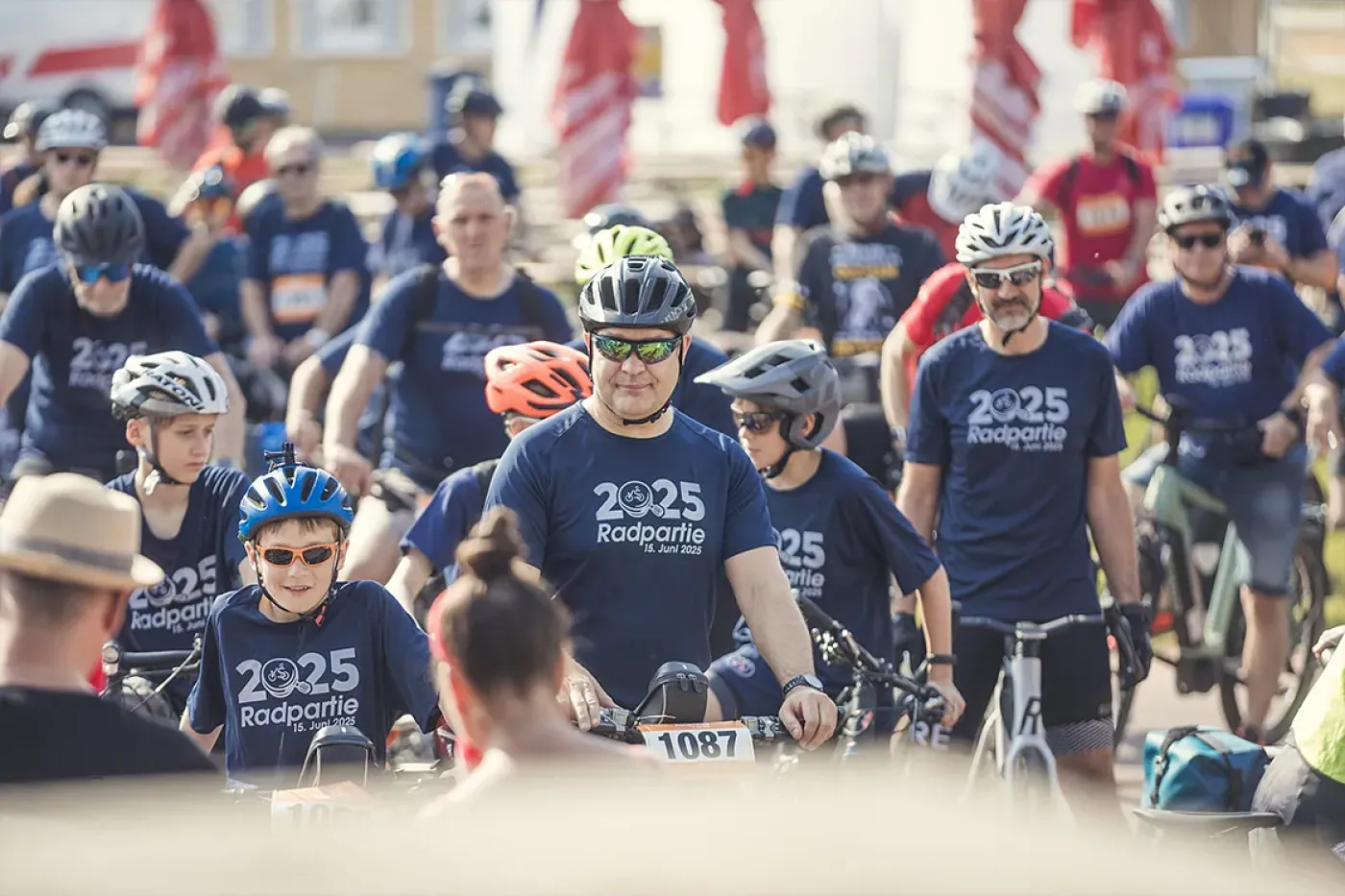 Viele Radfahrer in blauen Trikots an einer Starlinie