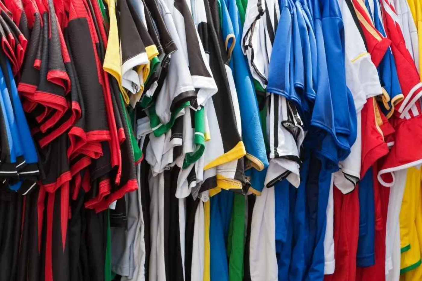 Bunte Trikots h&auml;ngen in Schrank
